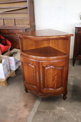 a small corner cabinet in the middle of a room
