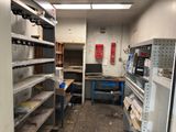 a room filled with shelves and a computer on a desk