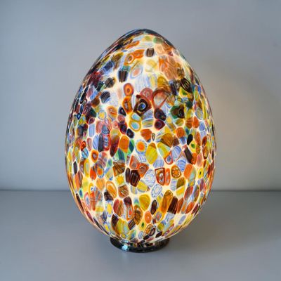un œuf en verre coloré posé sur une table