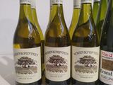 six bottles of wine are lined up in a row on a table