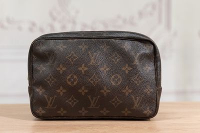 a louis vuitt toilet bag sitting on top of a wooden table