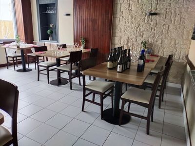 des tables et des chaises dans un restaurant, avec des bouteilles de vin et des bouteilles de vin