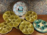 many plates and bowls on a table with a vase