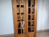 a tall wooden cabinet with glass doors in a room