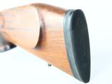 an image of a wooden rifle on a white surface with a white background
