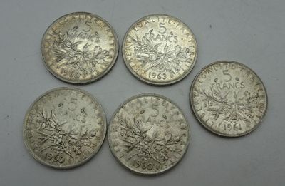 four silver coins are shown on a white surface