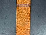 an orange leather case sitting on top of a black table