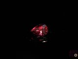 a close up of a red diamond on a black surface