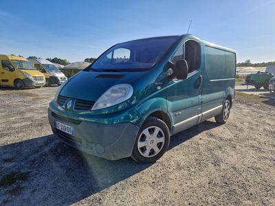 La camionnette verte est garée sur un parking, avec d'autres voitures en arrière-plan.