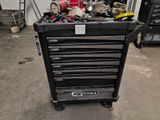 a black tool box with tools in it in a garage