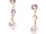 une paire de boucles d'oreilles en perles et diamants sur fond blanc