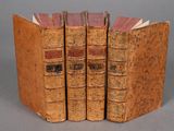 trois vieux livres sont empilés sur une table