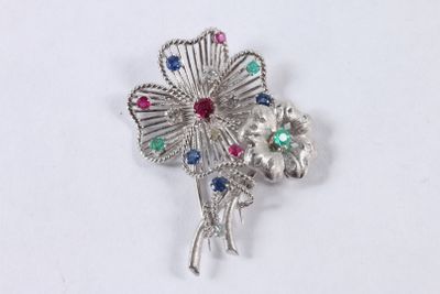 broche en forme de fleur en argent, ornée de pierres multicolores sur fond blanc