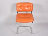an orange chair that is sitting on a white surface