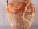 un grand vase muni d'une anse, posé sur une table