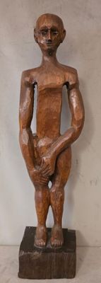 statue représentant un homme tenant un bébé dans ses bras, posée sur un socle en bois