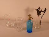 three glass vases and a bottle sitting on a table