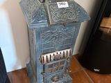 a small blue stove with a sign on the top of it