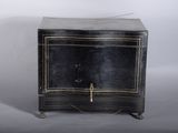 a small black cabinet with a gold decoration on the door