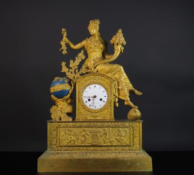 une horloge en or surmontée d'une statue
