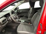 the interior of a red car with a black leather seat and steering wheel