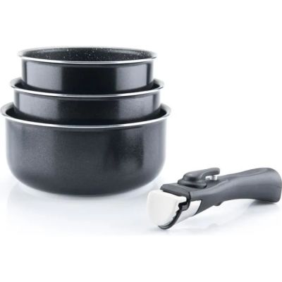 trois casseroles noires et une bouteille de vin posées sur un plan de travail blanc