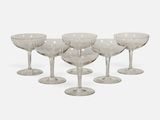 six clear wine glasses sitting on top of each other on a white surface