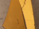 a close up of a yellow metal table with a curved top
