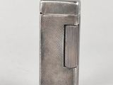 a close up of a silver lighter on a white surface