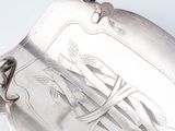 a silver plate with a design on it on a white surface