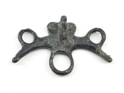 a metal object with a cross on it on a white surface