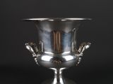 an antique silver plated urn with two hands on the base