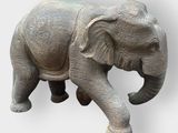 a statue of an elephant that is standing on a white surface