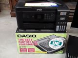 a black printer sitting on top of a box next to a computer