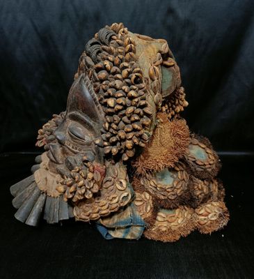 Imposant masque en bois richement orné de cauris, clochettes, herbes,  - Photo 1