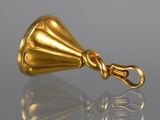 an image of a gold bell hanging from a hook on a reflective surface