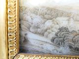une photo d'un tableau représentant un paysage, dans un cadre doré