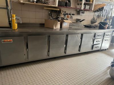 une grande cuisine en inox avec beaucoup de plans de travail