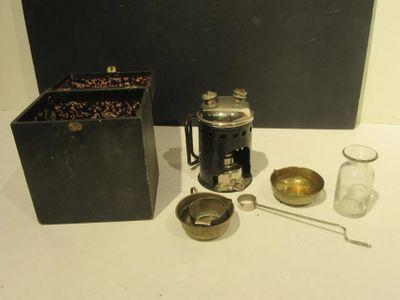 a coffee pot, a cup, a spoon, and a container on a table