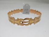 a close up of a gold bracelet on a white surface