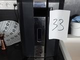 une cafetière noire posée sur le plan de travail d'une cuisine