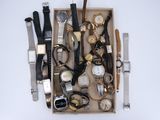une boîte remplie de montres et d'autres montres posées sur une table