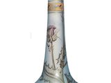 un vase en verre orné d'une fleur, posé sur une surface blanche
