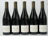 six bottles of wine are lined up in a row on a table