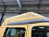 a yellow van with a roof top covered in a tarp