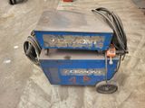 an image of a blue machine sitting on top of a cement floor