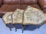 two tables that are sitting on the floor near a couch