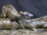 a bronze statue of a sheep and a dog on a log