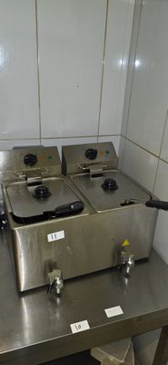 three deep fryers sitting on a table in a kitchen