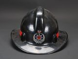 a silver fireman ' s helmet with a red ribbon on it